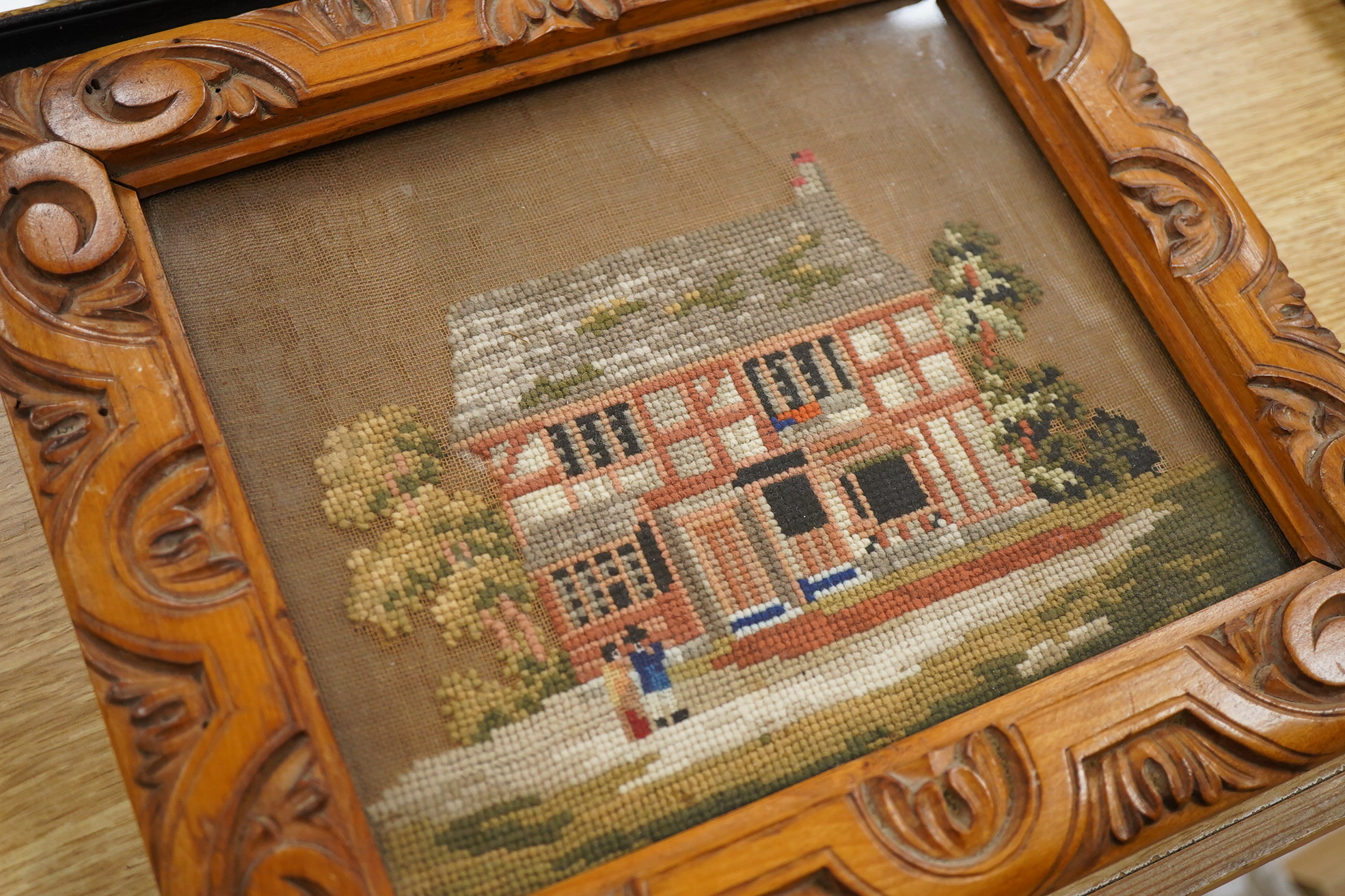 A 19th century heavily embroidered wool work of a figure and dog in a wooded landscape - 38cm x 33cm, together with smaller wool work of figures by a house. Condition - both are still strong in colour without damage.